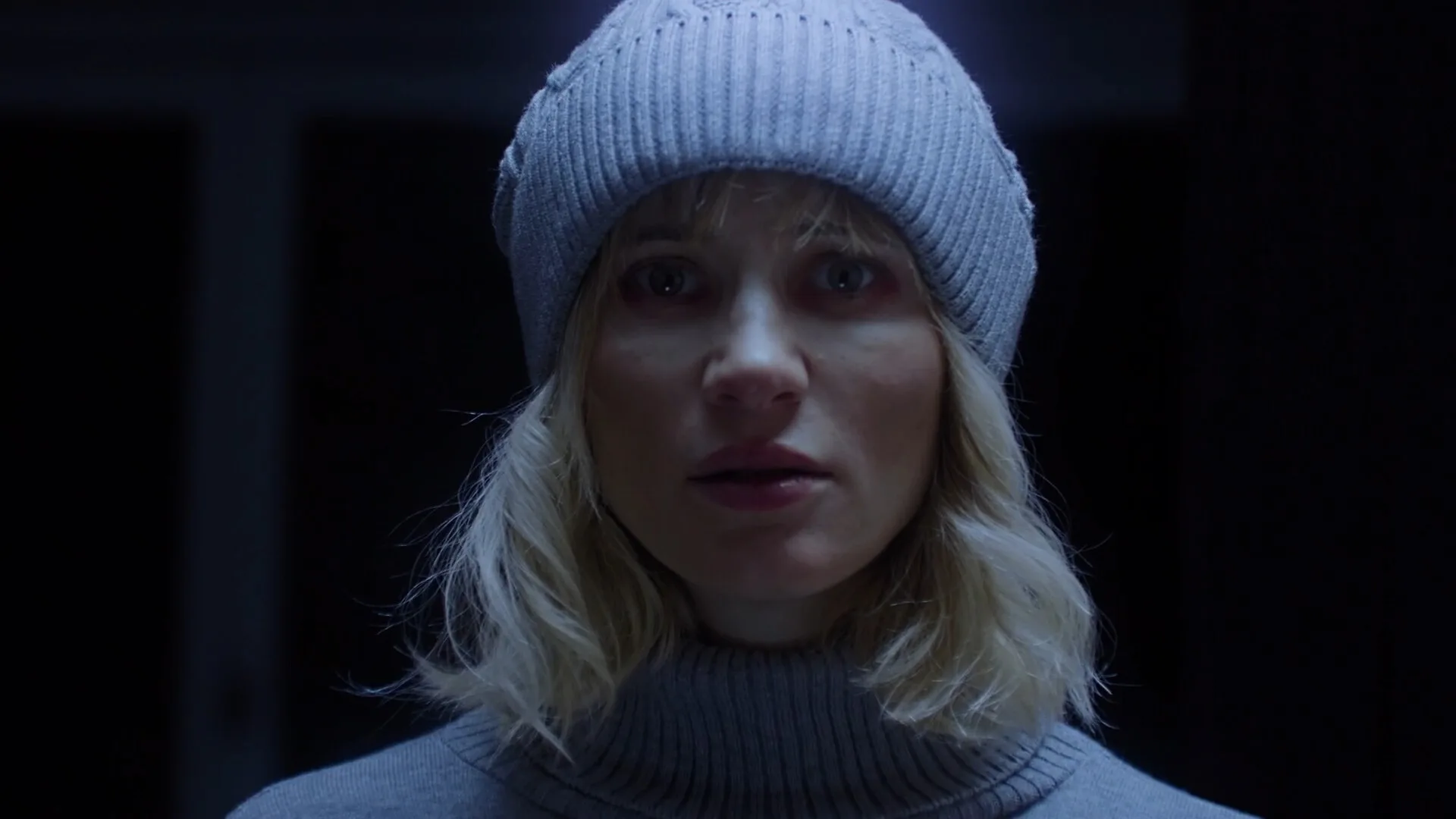 Live-action close-up of Julia in a grey beanie, from the Tenebris Somnia store page